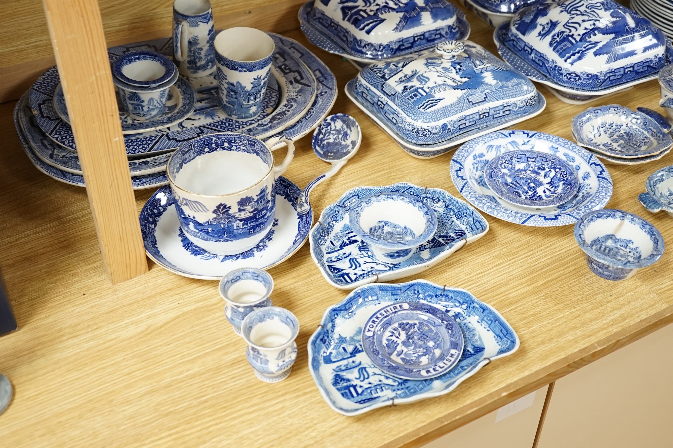 A mixed collection of Willow pattern blue and white dinnerware, including four tureens and covers, plates meat dishes etc. (large quantity). Condition - varied poor to fair to good
